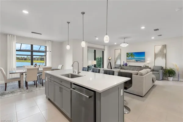a large kitchen with kitchen island a sink table and chairs