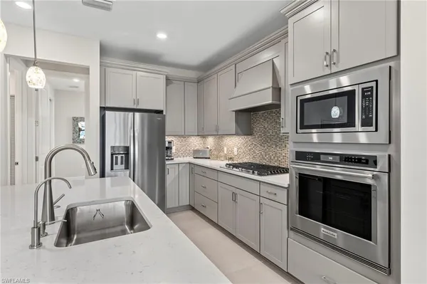 a kitchen with stainless steel appliances granite countertop a stove microwave and a sink