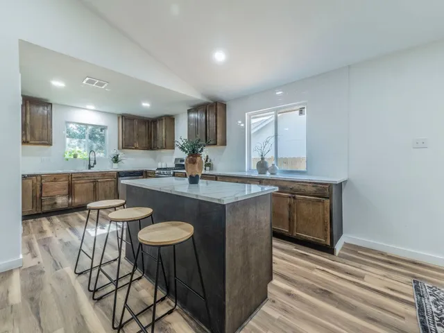 a kitchen with granite countertop a sink and a refrigerator