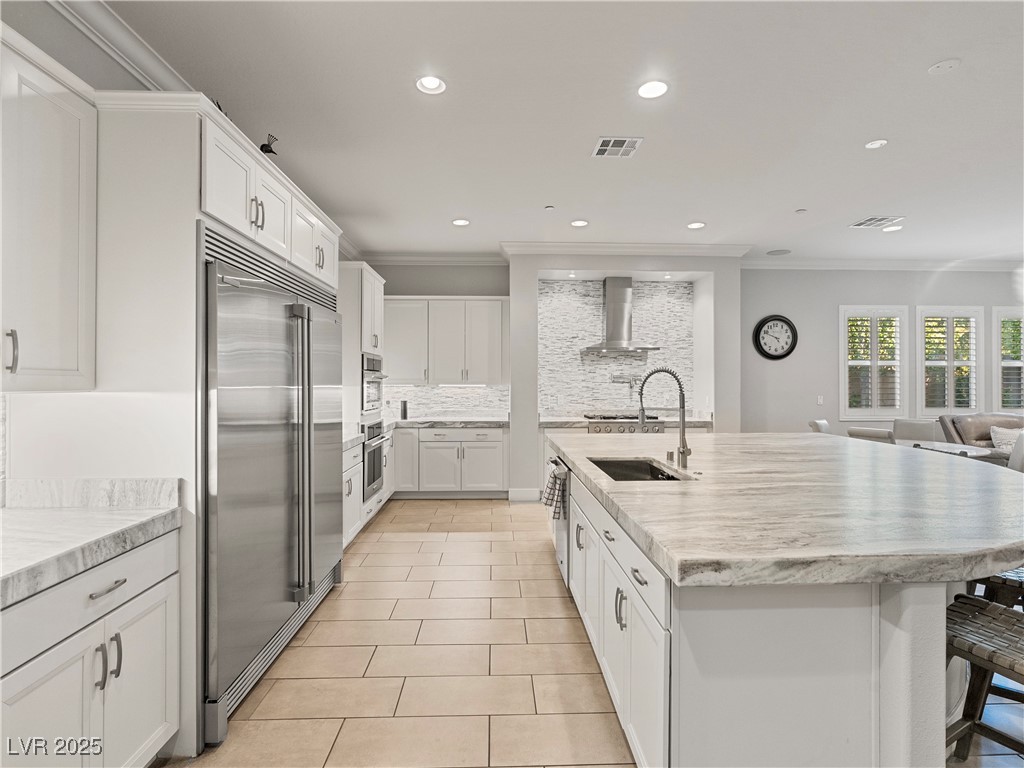 8775 Helena Avenue Las Vegas, NV 89129 - Photo 11 of 72 Kitchen featuring ornamental molding, white cabinetry, a breakfast bar area, a center island with sink, and stainless steel appliances