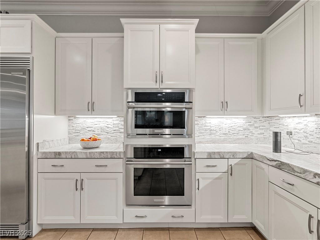 8775 Helena Avenue Las Vegas, NV 89129 - Photo 16 of 72 Kitchen featuring white cabinetry, tasteful backsplash, appliances with stainless steel finishes, light tile patterned floors, and ornamental molding