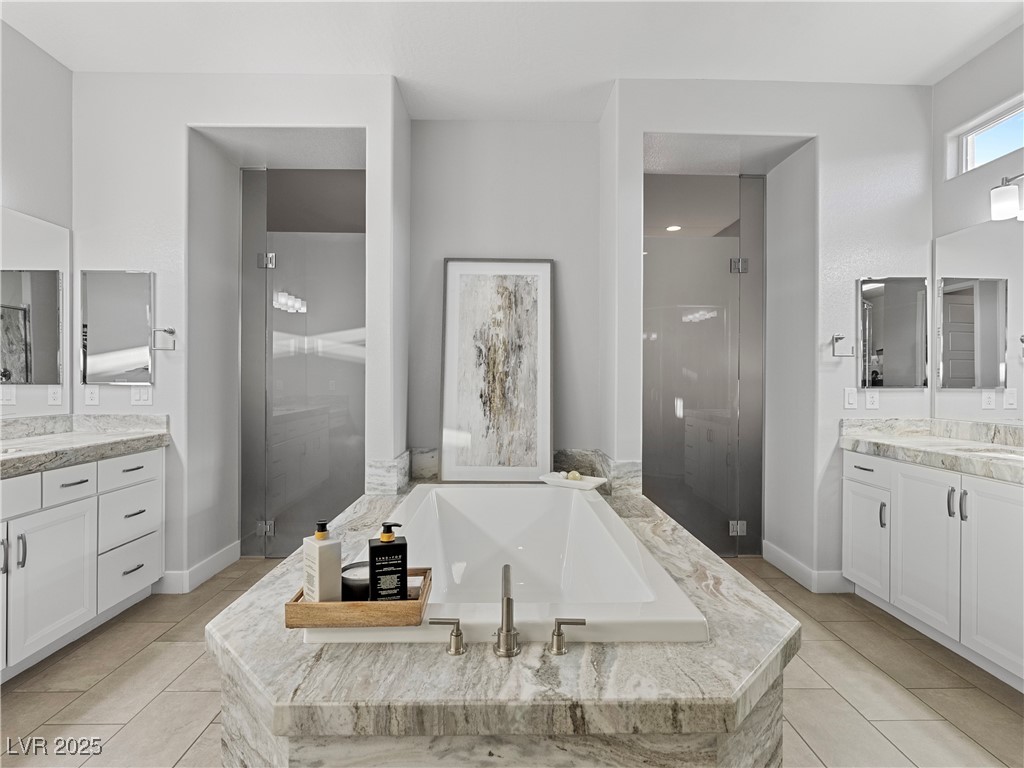 8775 Helena Avenue Las Vegas, NV 89129 - Photo 24 of 72 Bathroom with two vanities, a garden tub, a stall shower, and light tile patterned floors
