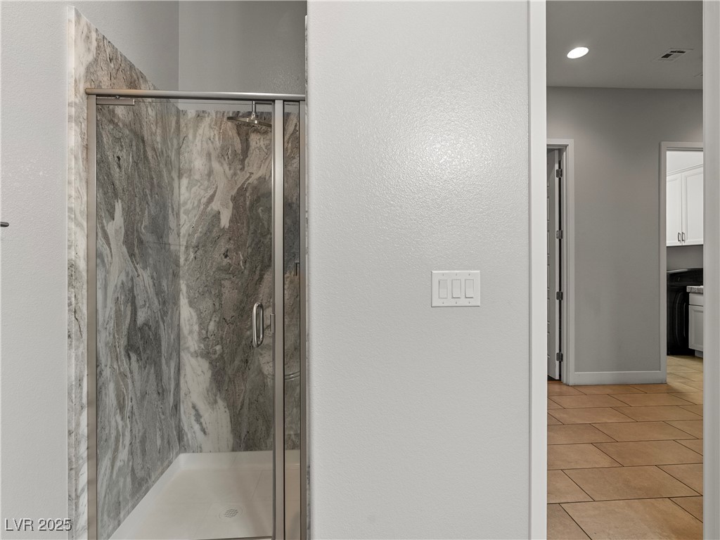 8775 Helena Avenue Las Vegas, NV 89129 - Photo 44 of 72 Bathroom featuring a marble finish shower, light tile patterned floors, and a textured wall