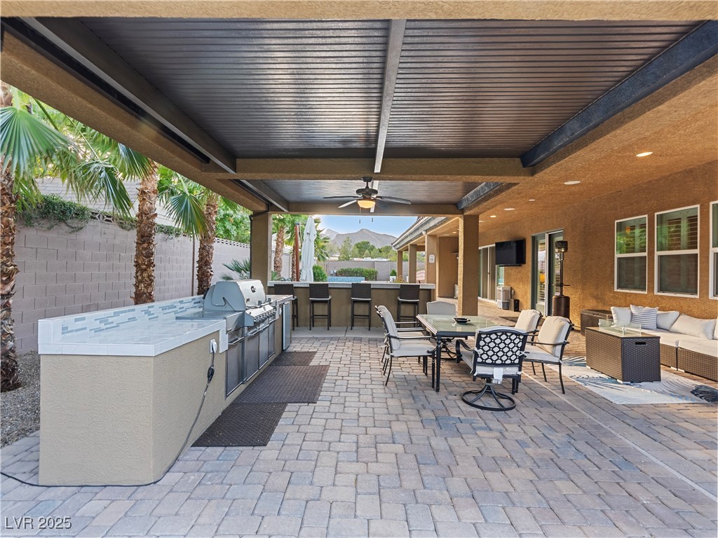 8775 Helena Avenue Las Vegas, NV 89129 - Photo 55 of 72 View of patio / terrace with an outdoor kitchen, outdoor lounge area, ceiling fan, and outdoor dining space