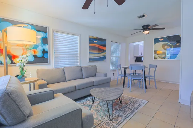 a living room with furniture a flat screen tv and a window