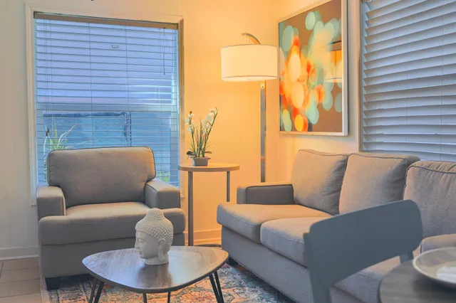 a living room with furniture a fireplace and a large window