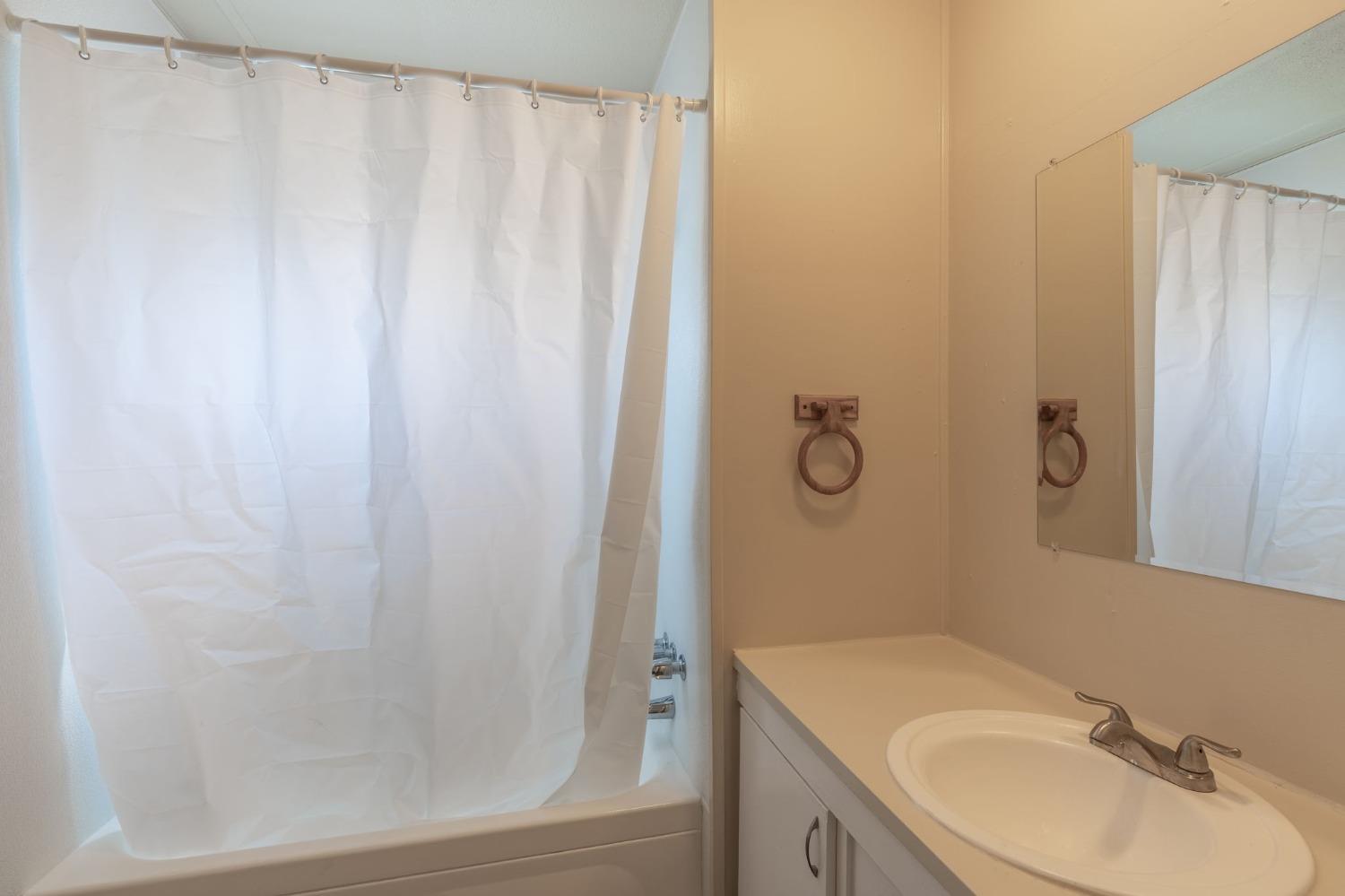 5835 Cherokee Road, Unit 7 Stockton, CA 95215 - Photo 11 of 16 a bathroom with a granite countertop sink and a mirror
