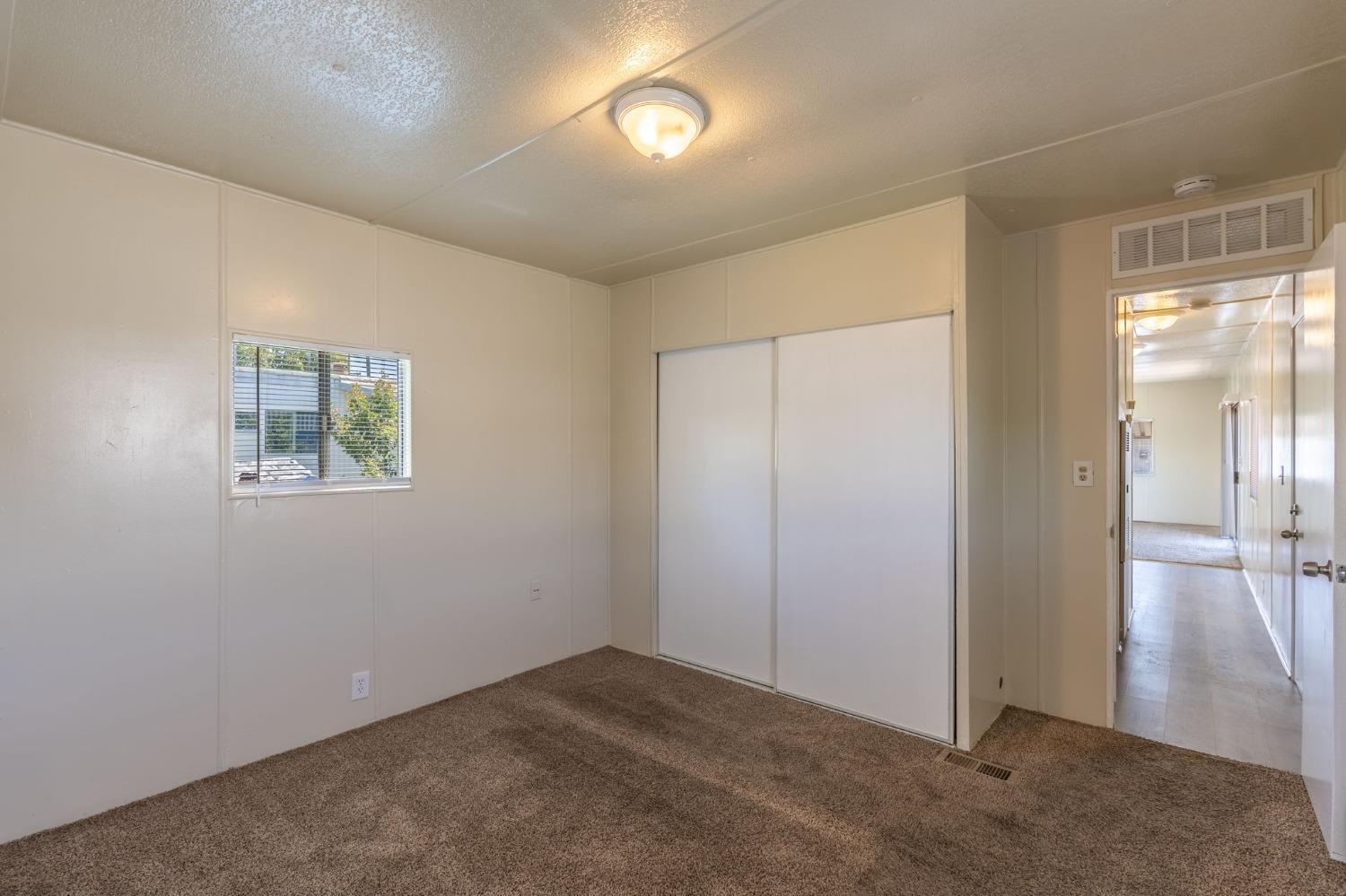 5835 Cherokee Road, Unit 7 Stockton, CA 95215 - Photo 14 of 16 an empty room with wooden floor and windows