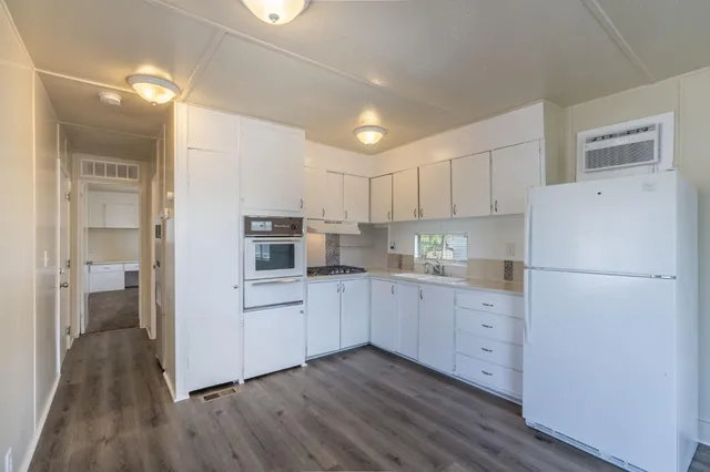 a kitchen with cabinets and wooden floor