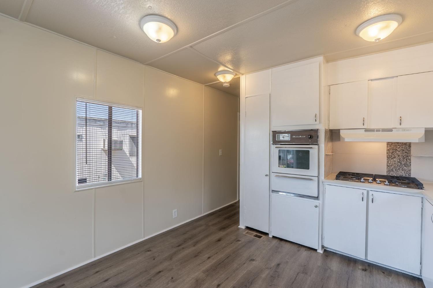 5835 Cherokee Road, Unit 7 Stockton, CA 95215 - Photo 9 of 16 a kitchen with a refrigerator and white cabinets