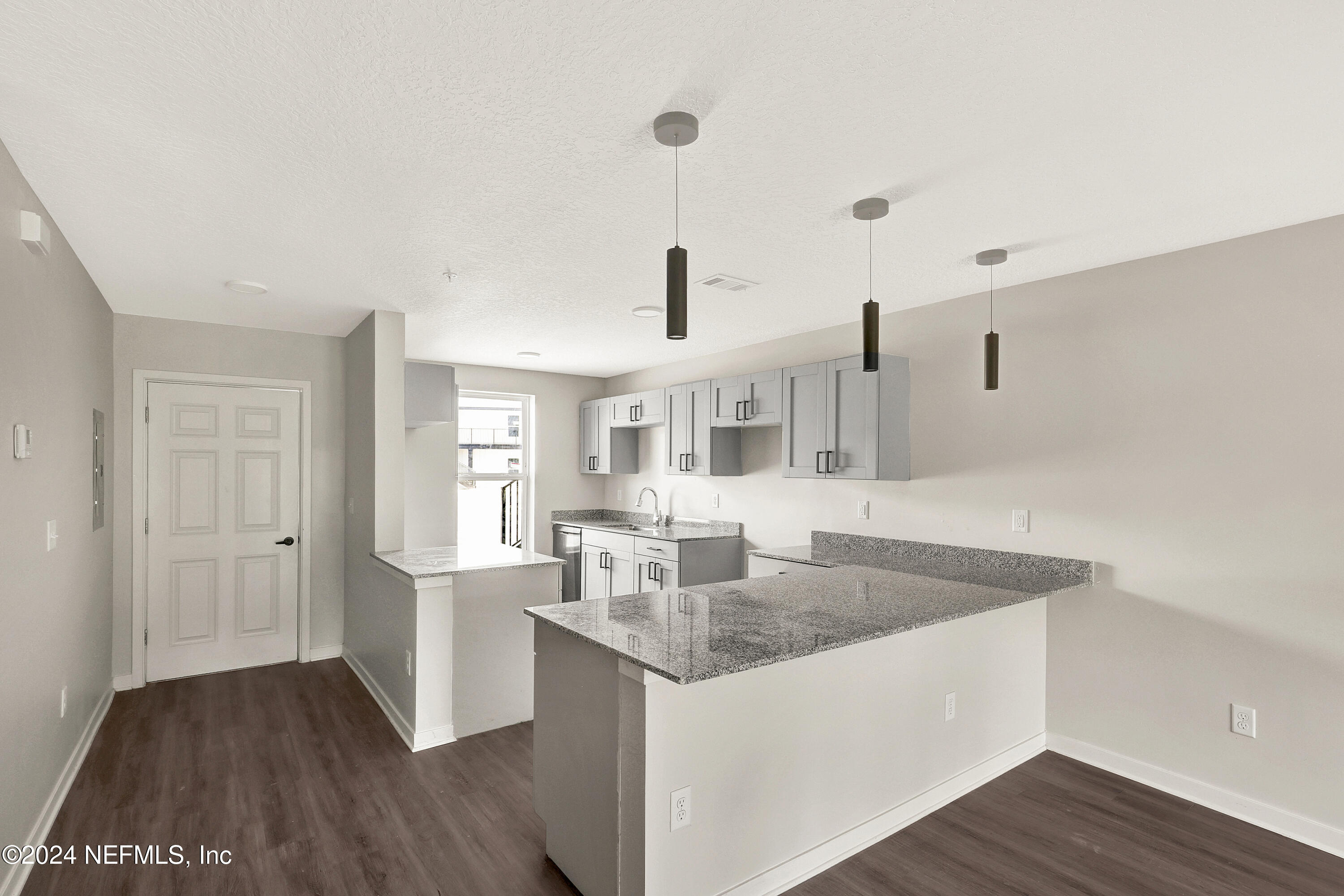 10109 Old St Augustine Road, Unit 1104 Jacksonville, FL 32257 - Photo 8 of 10 a kitchen with granite countertop a sink and dishwasher with wooden floor