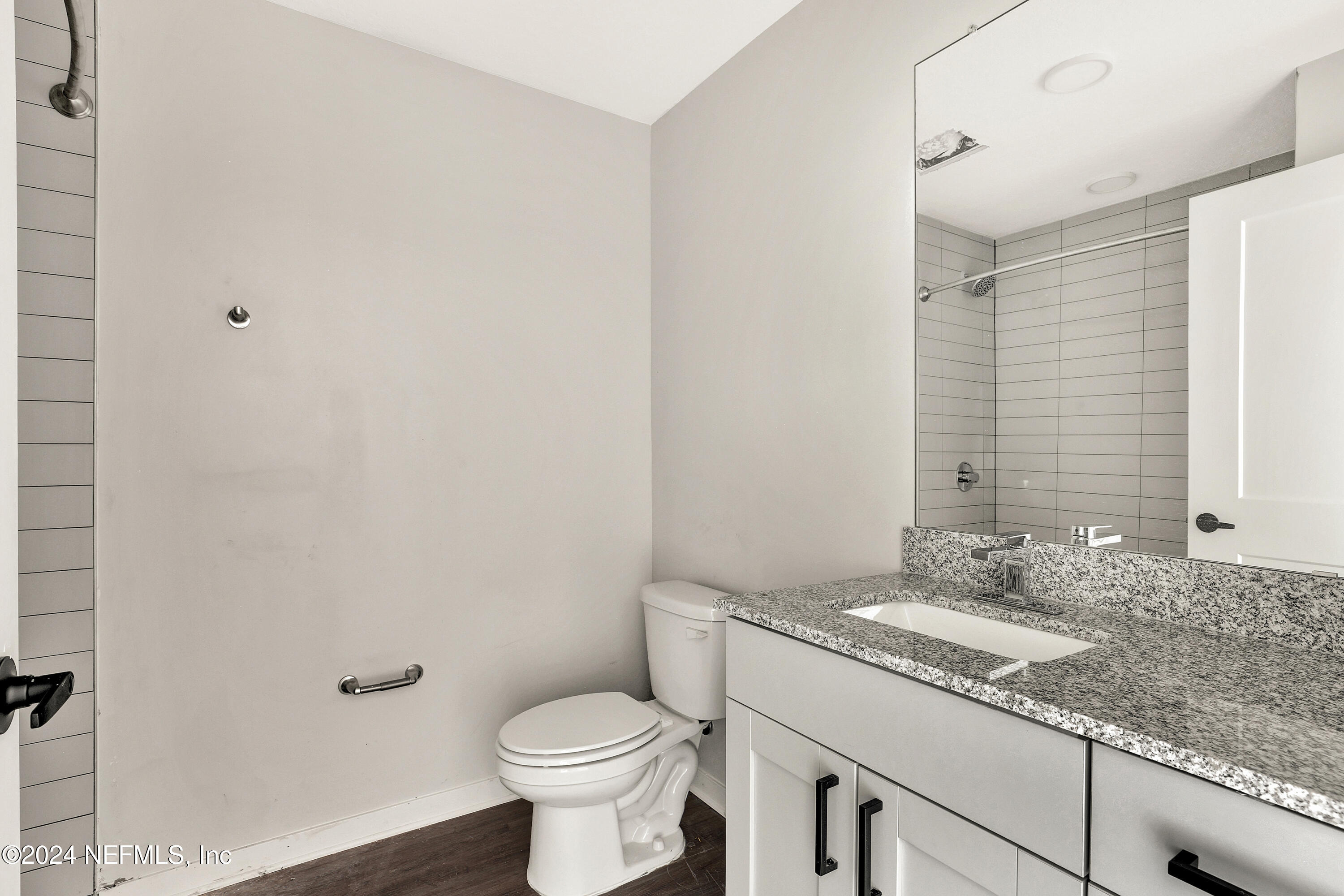 10109 Old St Augustine Road, Unit 1104 Jacksonville, FL 32257 - Photo 10 of 10 a bathroom with a granite countertop sink a toilet and a mirror