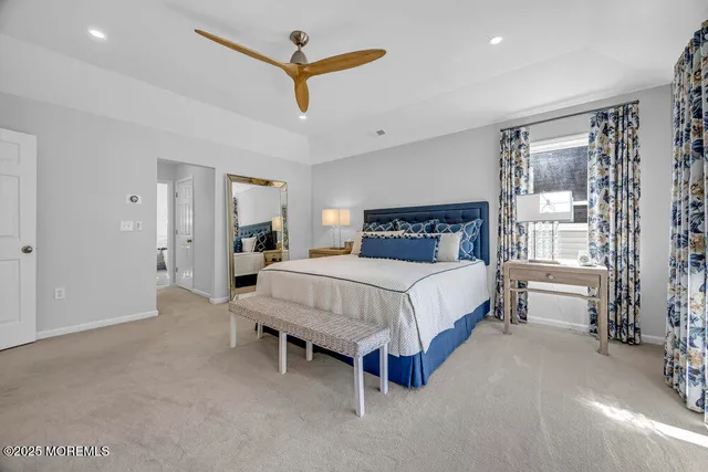 a bedroom with a bed and a flat tv screen on dresser