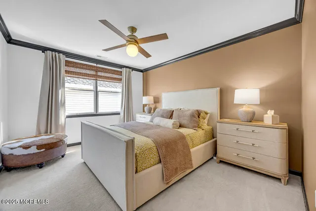 a spacious bedroom with a bed a dresser and a large window