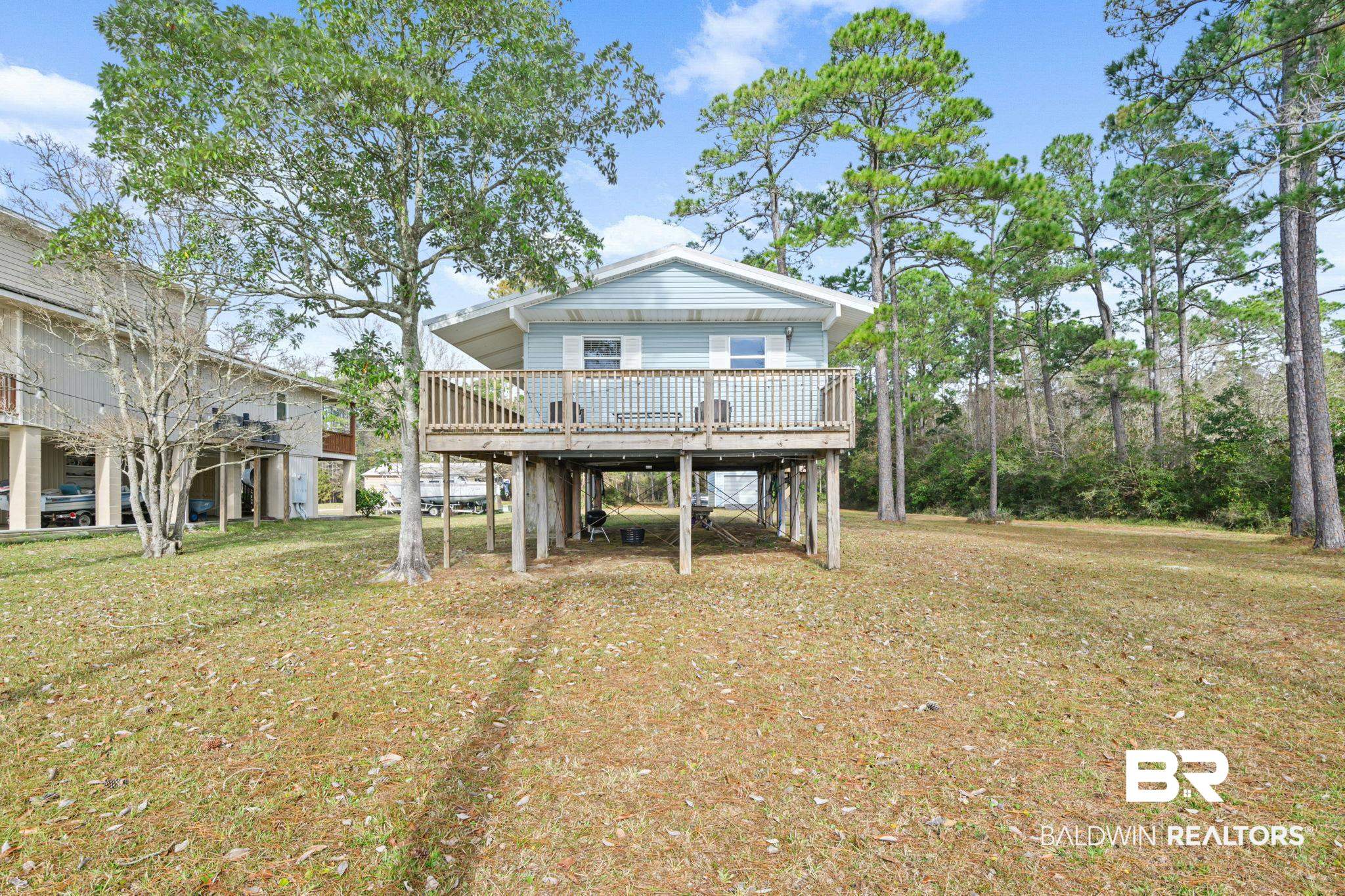 Back of property featuring a deck, a yard, and a carport