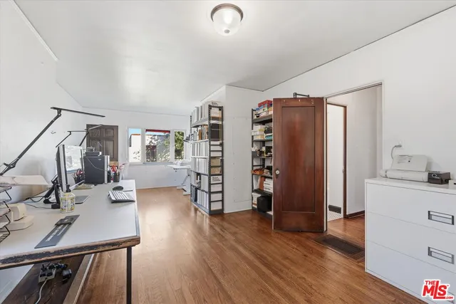 a view of a workspace with furniture and wooden floor