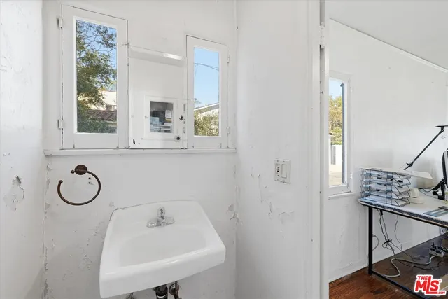 a bathroom with a sink a window and mirror