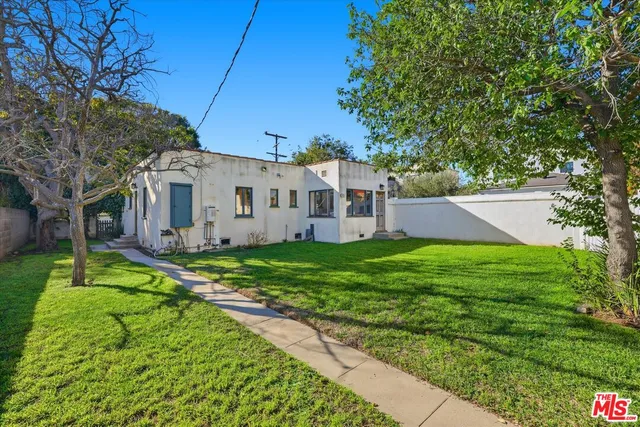 a view of a house with backyard and a tree