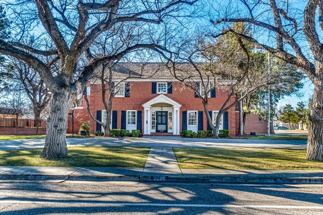 a front view of a house with yard and green space