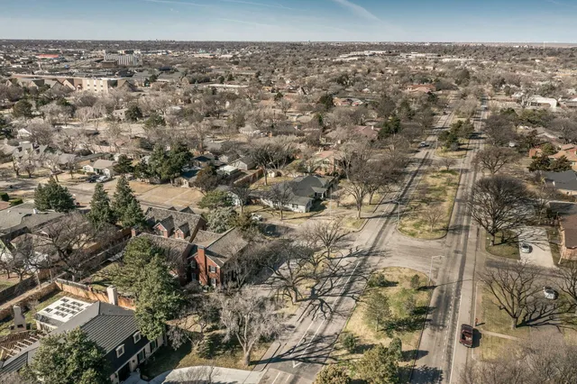 a view of an empty room with wooden floor fireplace and a window