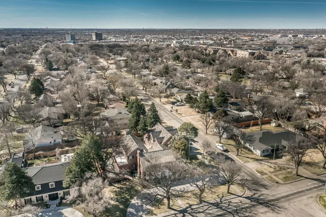 a view of an empty room with wooden floor and a fireplace