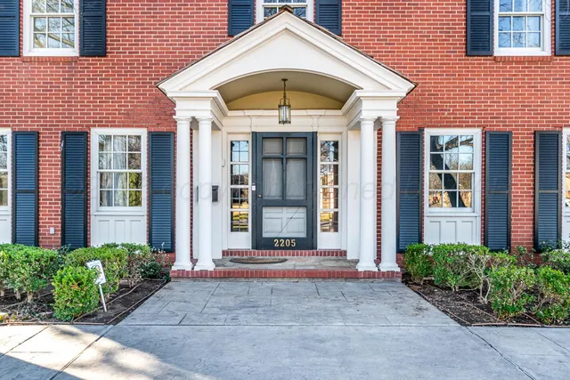 a view of large house with a big yard and large trees