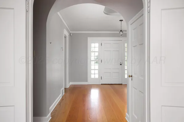 a view of an empty room with window and wooden floor