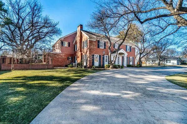 a front view of a house with a yard and trees