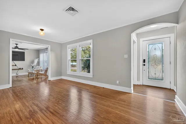 an empty room with wooden floor and a bathroom