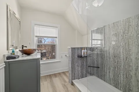 a kitchen with stainless steel appliances granite countertop a refrigerator a sink and dishwasher with wooden floor