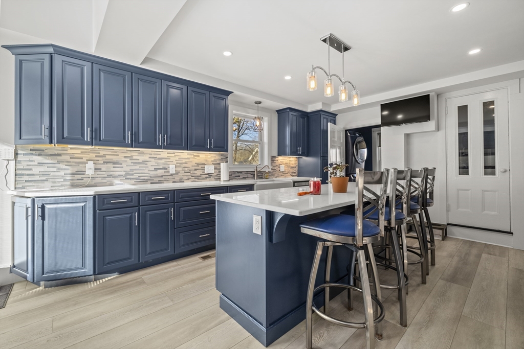 36 Summer Street Holbrook, MA 02343 - Photo 5 of 35 a kitchen with kitchen island granite countertop wooden floors cabinets a sink and a counter