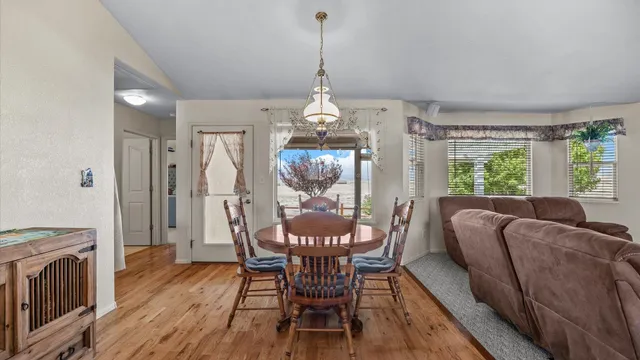a dining room with furniture a chandelier and wooden floor