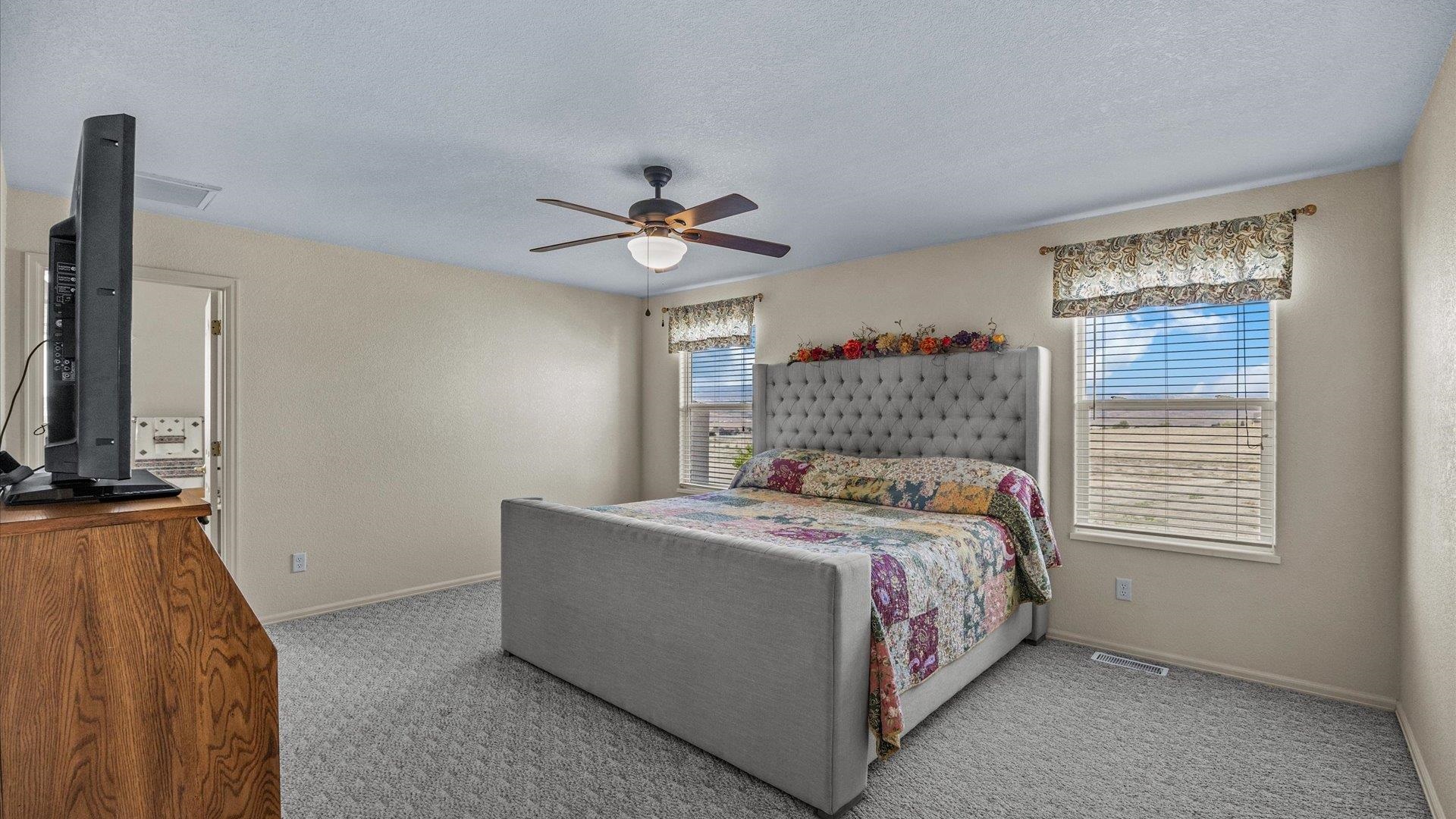 475 Los Broncos Road Whitewater, CO 81527 - Photo 14 of 41 a bedroom with a bed a chandelier and a window