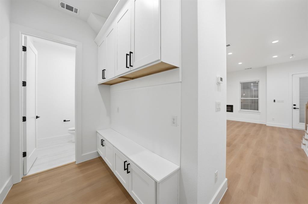 306 East 7th Street Dallas, TX 75203 - Photo 22 of 22 Mudroom with built-in bench and upper cabinetry, accented by matte black hardware