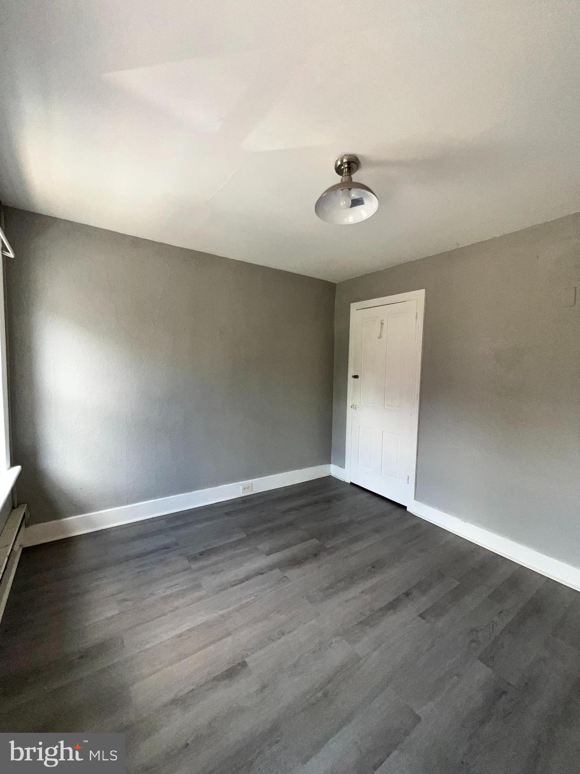 1264 Muhlenberg Street Reading, PA 19602 - Photo 12 of 16 an empty room with wooden floor and windows