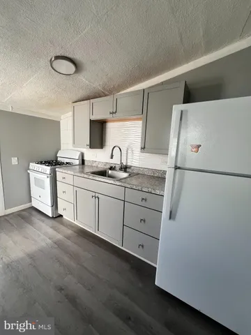 a kitchen with a sink a stove a refrigerator and cabinets