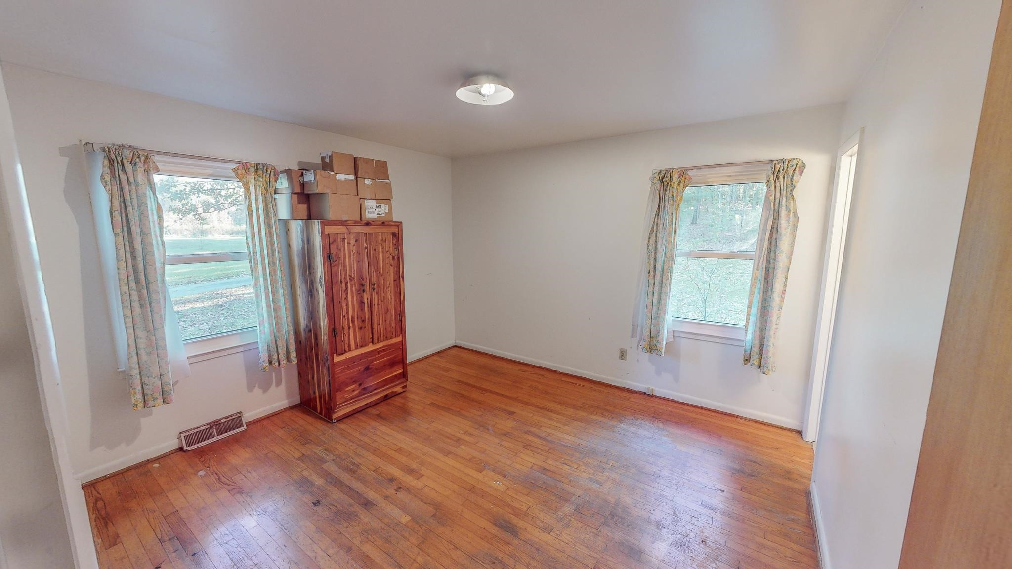 624 Frank Street Roxboro, NC 27573 - Photo 11 of 22 an empty room with wooden floor and windows