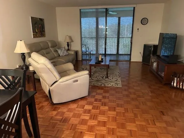 a living room with couches bookshelf and a flat screen tv