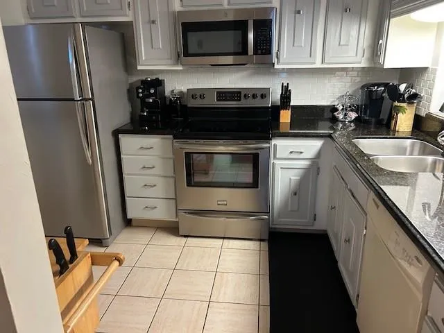 a kitchen with a refrigerator stove and cabinets