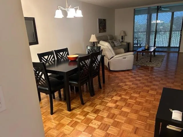 a living room with furniture a large window and a chandelier