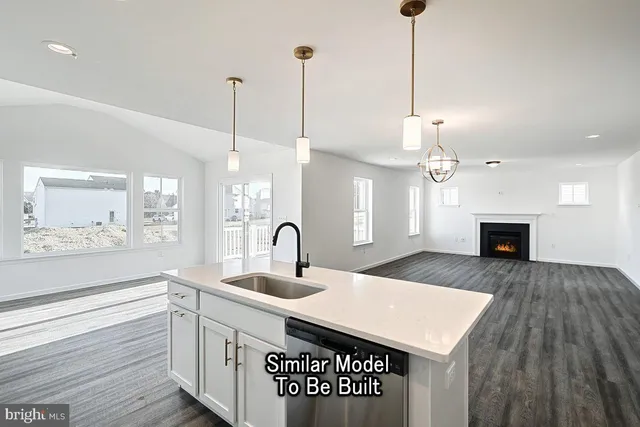 a kitchen with a sink a chandelier and wooden floor