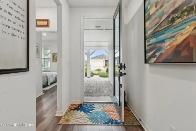 a large white kitchen with a large window a sink and cabinets