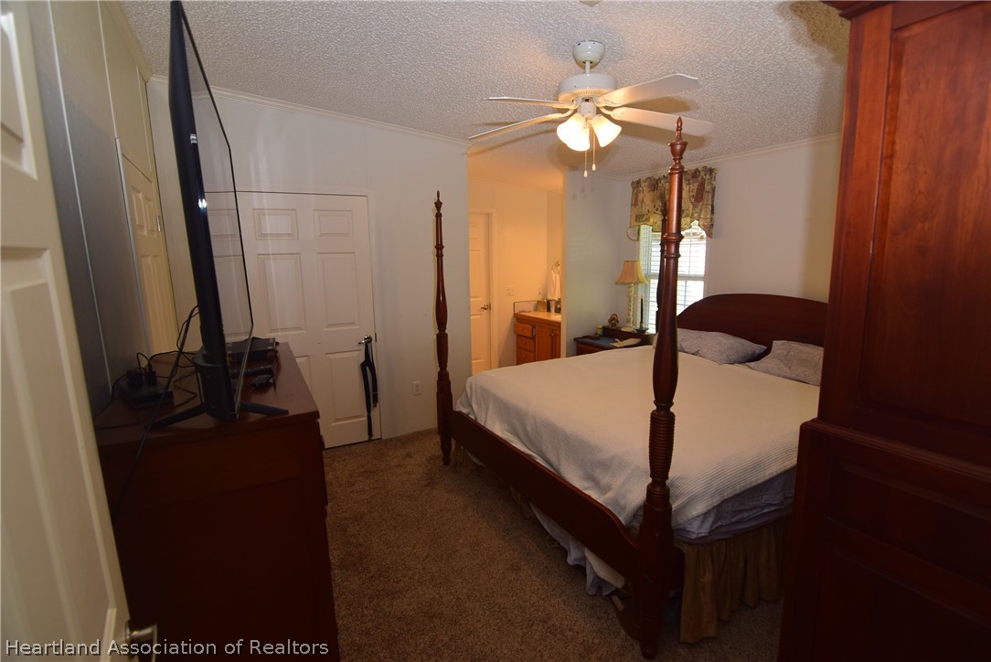3124 White Oak Road Lorida, FL 33857 - Photo 13 of 34 a bedroom with a bed a chandelier and a dresser