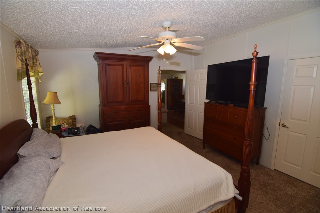 3124 White Oak Road Lorida, FL 33857 - Photo 14 of 34 a bedroom with a bed and a chandelier