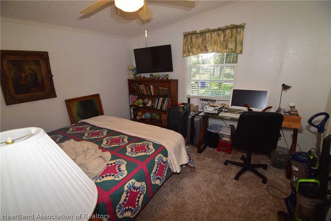 3124 White Oak Road Lorida, FL 33857 - Photo 25 of 34 a bedroom with a bed and a flat screen tv