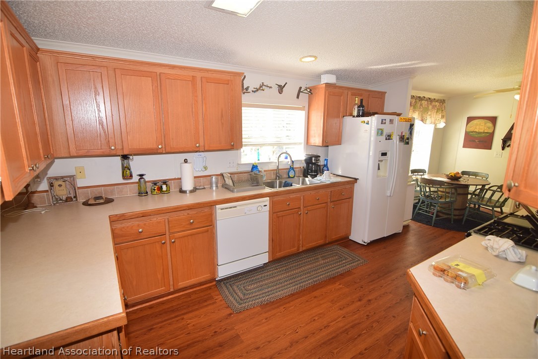3124 White Oak Road Lorida, FL 33857 - Photo 30 of 34 a kitchen with refrigerator a stove a sink cabinets and wooden floor