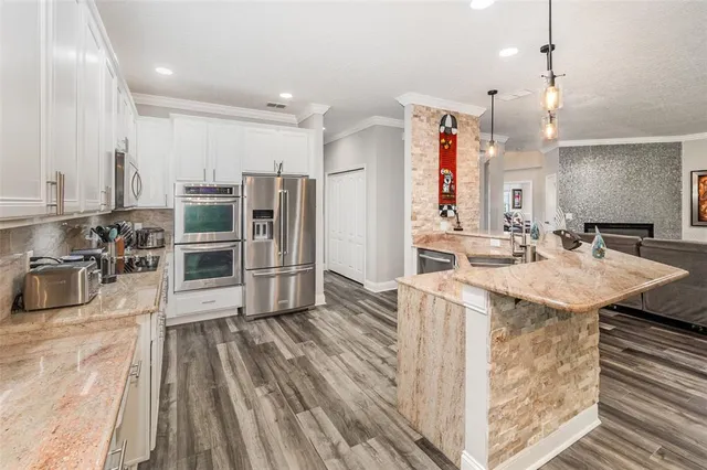a kitchen with stainless steel appliances granite countertop a sink and a refrigerator