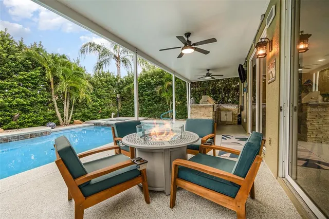 a view of a patio with table and chairs potted plants and large tree