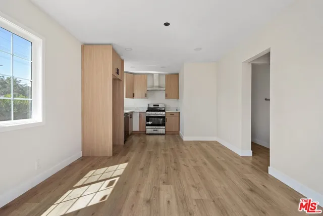 a view of a kitchen with wooden floor electronic appliances and windows
