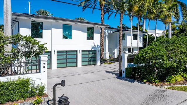 a view of a house with a small yard plants and a large tree